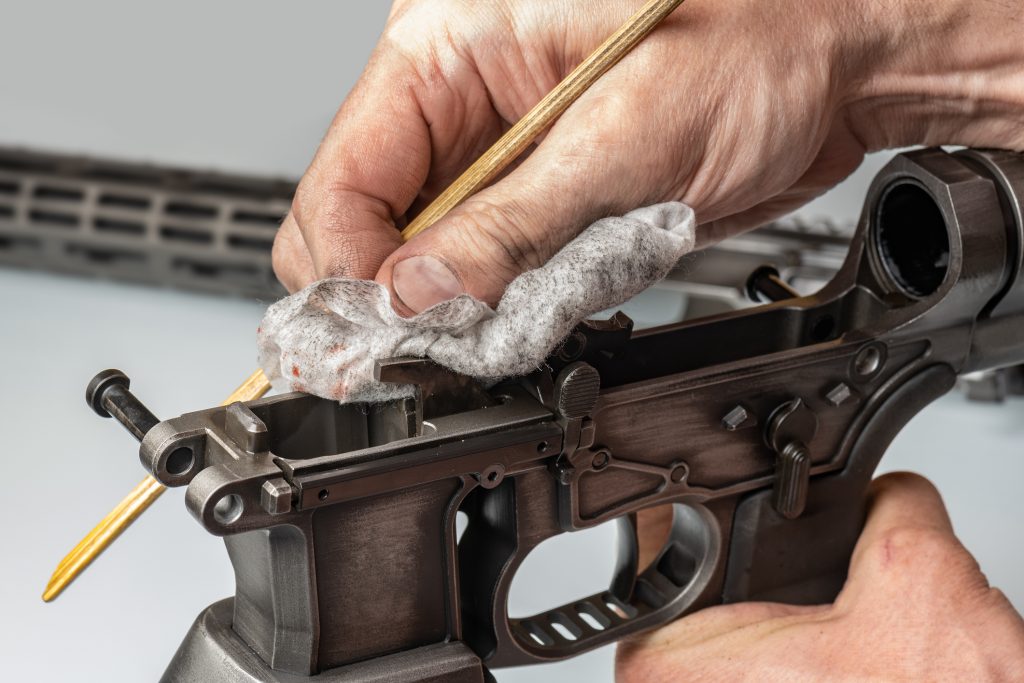 closeup of a gunsmith's hands cleaning a firearm